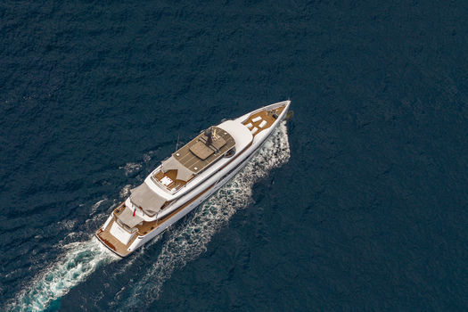 Aerial view of a luxury motor yacht cruising through the deep blue Mediterranean Sea near the coast of Cannes Provence Alpes Cote d Azur France. Aerial view of a luxury motor yacht cruising through the deep blue Mediterranean Sea near the coast of Cannes Provence Alpes Cote d Azur France.