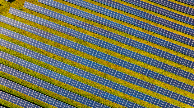 Aerial view of rows of solar panels installed in a green field capturing the clean energy infrastructure. Dorset England United Kingdom. Aerial view of rows of solar panels installed in a green field capturing the clean energy infrastructure. Dorset England United Kingdom.