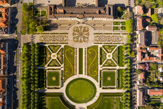 Aerial view of the historic Ludwigsburg Palace featuring its symmetrical baroque gardens manicured lawns and gravel pathways in Ludwigsburg Baden Wurttemberg Germany.