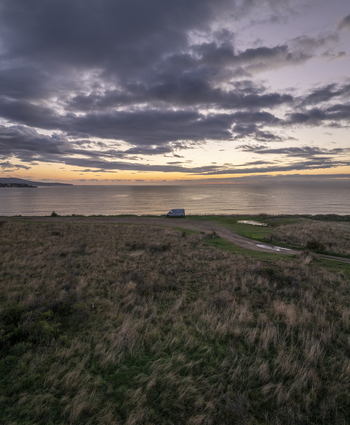 Aerial view of a van parked on the grassy coast overlooking the calm sea during a dramatic sunset in Nessebar Burgas Bulgaria. Aerial view of a van parked on the grassy coast overlooking the calm sea during a dramatic sunset in Nessebar Burgas Bulgaria.