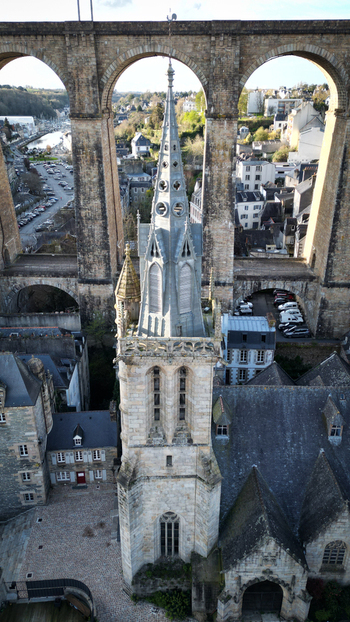 Aerial view of Eglise Saint Melaine de Morlaix spire framed by the massive arches of the historic stone viaduct in Morlaix Bretagne France. Aerial view of Eglise Saint Melaine de Morlaix spire framed by the massive arches of the historic stone viaduct in Morlaix Bretagne France.