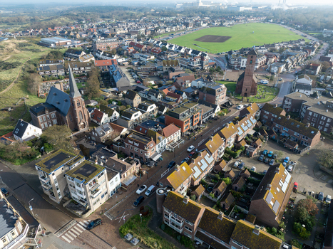 Aerial view of the coastal village featuring historic churches residential houses and a large green field Wijk aan Zee North Holland Netherlands.