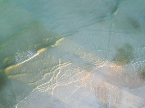 Aerial view of the shoreline s gentle waves caressing the light sand creating a serene blend of turquoise and beige Pantai Tanjung Aan West Nusa Tenggara Indonesia. Aerial view of the shoreline s gentle waves caressing the light sand creating a serene blend of turquoise and beige Pantai Tanjung Aan West Nusa Tenggara Indonesia.