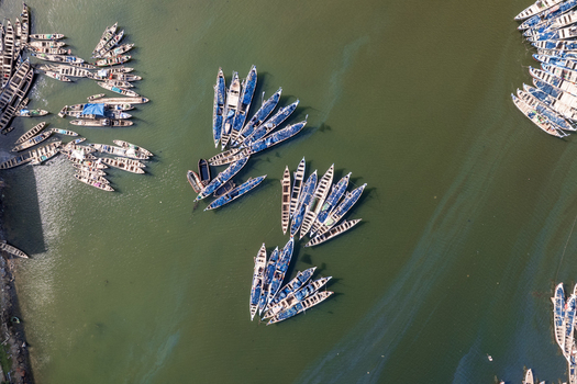 Aerial view of a fleet of boats clustered in the murky harbor waters creating a mesmerizing mosaic of maritime activity Tema Ghana. Aerial view of a fleet of boats clustered in the murky harbor waters creating a mesmerizing mosaic of maritime activity Tema Ghana.