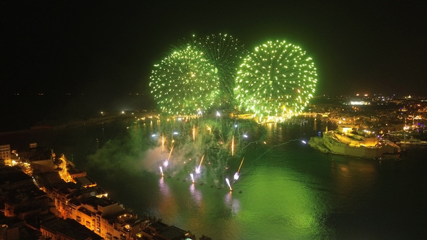 Aerial view of green fireworks illuminating the night sky over the Grand Harbour with historic city lights and fortifications in Valletta Port Region Malta. Aerial view of green fireworks illuminating the night sky over the Grand Harbour with historic city lights and fortifications in Valletta Port Region Malta.