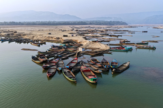 Aerial view of Jadukata River with numerous wooden boats moored along the sandy riverbank in Sunamganj Sylhet Division Bangladesh. Aerial view of Jadukata River with numerous wooden boats moored along the sandy riverbank in Sunamganj Sylhet Division Bangladesh.