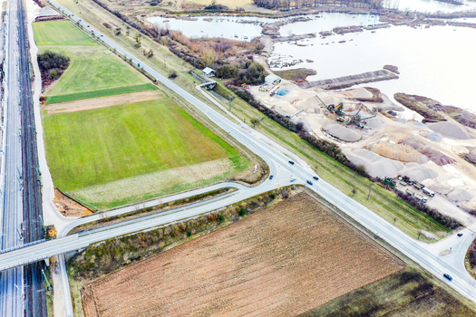 Aerial view of the rural landscape featuring a highway railway tracks and a gravel pit with water ponds in Buttenheim Bavaria Germany. Aerial view of the rural landscape featuring a highway railway tracks and a gravel pit with water ponds in Buttenheim Bavaria Germany.