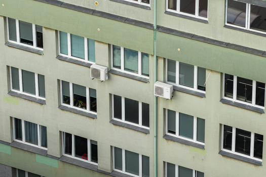 Aerial view of the facade of a residential apartment building featuring multiple windows and wall mounted air conditioning units Warsaw Masovian Voivodeship Poland. Aerial view of the facade of a residential apartment building featuring multiple windows and wall mounted air conditioning units Warsaw Masovian Voivodeship Poland.