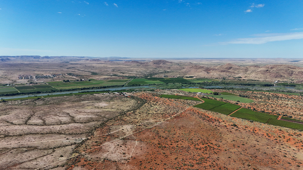 Aerial view of a striking contrast between the arid red toned earth and the lush green ribbon of life along the river Karoo Desert Northern Cape South Africa. Aerial view of a striking contrast between the arid red toned earth and the lush green ribbon of life along the river Karoo Desert Northern Cape South Africa.