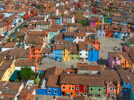 Aerial view of a vibrant mosaic of colorful buildings clustered tightly together in Burano a small island near Venice creating a dazzling display of color Venice Veneto Italy. Aerial view of a vibrant mosaic of colorful buildings clustered tightly together in Burano a small island near Venice creating a dazzling display of color Venice Veneto Italy.