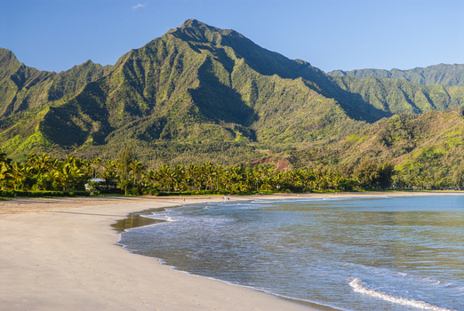 View of the sandy beach and lush green mountains of Hanalei Bay in Hanalei Hawaii United States. View of the sandy beach and lush green mountains of Hanalei Bay in Hanalei Hawaii United States.