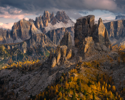 Aerial view of the Cinque Torri rock formations in the Dolomites with rugged limestone peaks golden larch forests and dramatic shadows in Cortina d Ampezzo Veneto Italy.