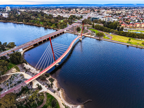Aerial view of Boorloo Bridge spanning the Swan River with lush parkland and the urban skyline of East Perth Western Australia Australia.