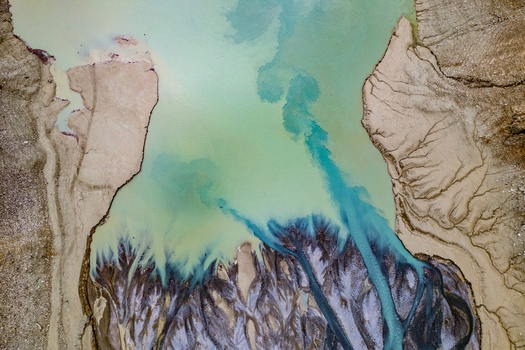 Aerial view of the turquoise glacial river sediment patterns and intricate silt deposits flowing into the riverbed near Prutz Tyrol Austria. Aerial view of the turquoise glacial river sediment patterns and intricate silt deposits flowing into the riverbed near Prutz Tyrol Austria.
