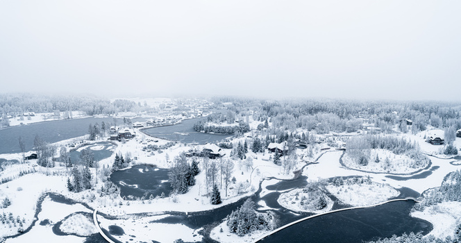 Aerial view of a snowy winter landscape with frozen ponds snow covered trees and scattered houses Latvia. Aerial view of a snowy winter landscape with frozen ponds snow covered trees and scattered houses Latvia.
