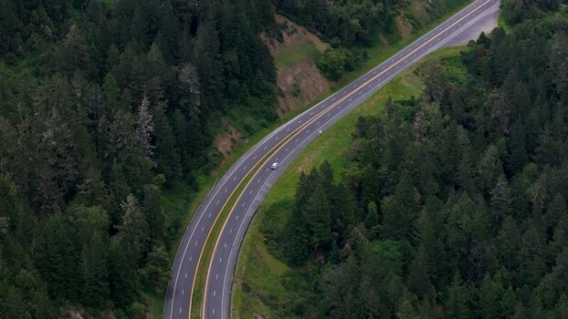 Aerial view of a highway winding through a forest United States. Aerial view of a highway winding through a forest United States.