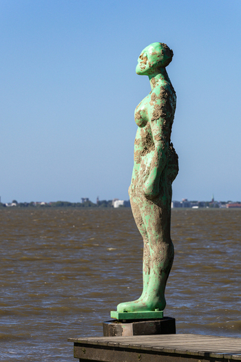 View of the green sculpture in Dangast standing on a wooden pier against the backdrop of the Jade Bight and a clear blue sky in Varel Lower Saxony Germany. View of the green sculpture in Dangast standing on a wooden pier against the backdrop of the Jade Bight and a clear blue sky in Varel Lower Saxony Germany.