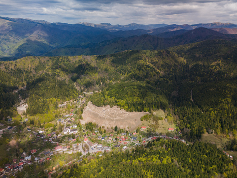 Aerial view of the historic mining village of Spania Dolina surrounded by lush green forests and rolling mountains under a cloudy sky Spania Dolina Banska Bystrica Regio Slovakia.