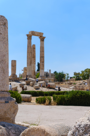 View of the ancient Temple of Hercules columns at the Amman Citadel with historic ruins and visitors under a clear blue sky in Amman Amman Governorate Jordan.