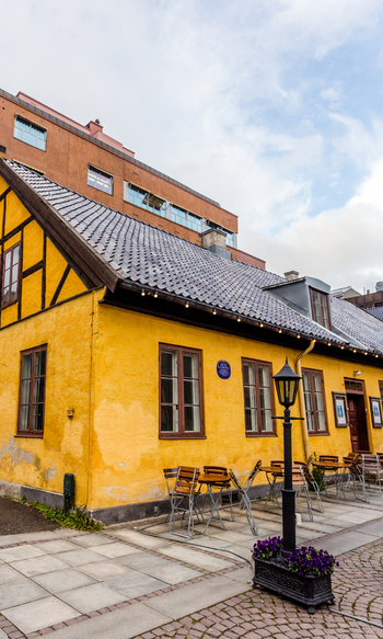 View of a quaint yellow building with dark brown timber framing stands out against the modern architecture in West Old Town West Old Town New Mexico Sweden. View of a quaint yellow building with dark brown timber framing stands out against the modern architecture in West Old Town West Old Town New Mexico Sweden.