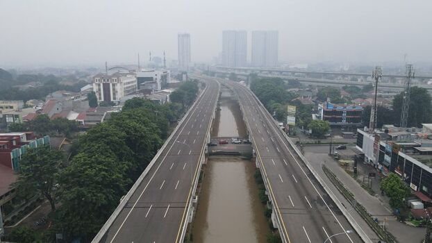 Aerial view of the elevated toll road running parallel to a river through the urban landscape of Bekasi Barat West Java Indonesia. Aerial view of the elevated toll road running parallel to a river through the urban landscape of Bekasi Barat West Java Indonesia.