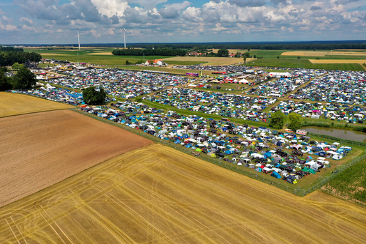 Herzogenaurach Germany 24 July 2025 Aerial view of the Open Beatz Festival campsite with thousands of tents and cars spread across green fields under a cloudy sky.