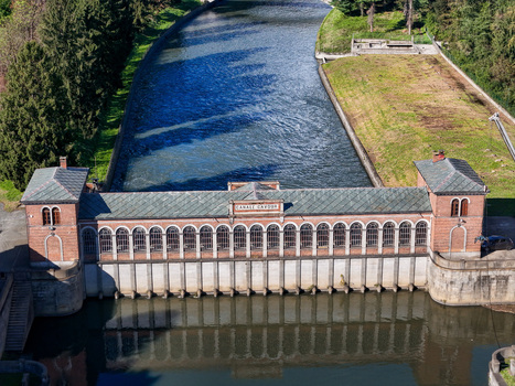 Aerial view of the historic Canale Cavour intake building with its distinctive arched windows and flowing water in Chivasso Piedmont Italy.