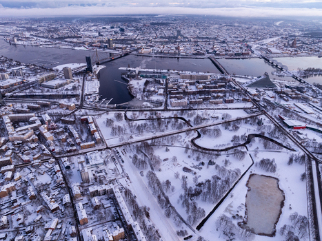 Aerial view of the snow covered cityscape of Riga featuring the Daugava River bridges and urban architecture during a winter sunrise in Riga Latvia.