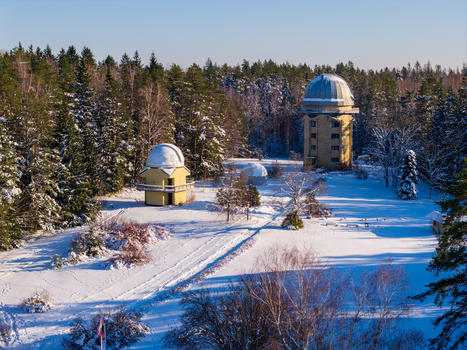 Aerial view of the Moletai Astronomical Observatory with its distinctive domes nestled in a snow covered pine forest under bright winter sunlight Kulionys Utenos apskritis Lithuania. Aerial view of the Moletai Astronomical Observatory with its distinctive domes nestled in a snow covered pine forest under bright winter sunlight Kulionys Utenos apskritis Lithuania.