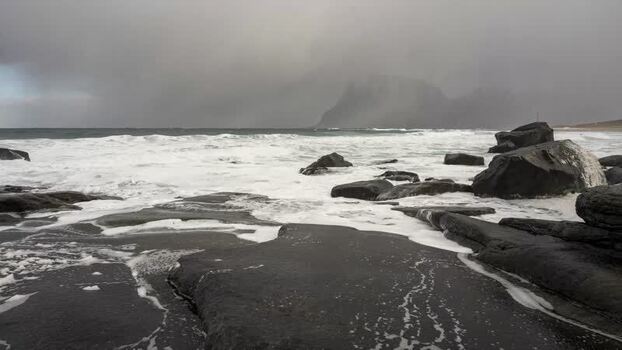 View of crashing waves on rocky shore in Lofoten Norway. View of crashing waves on rocky shore in Lofoten Norway.
