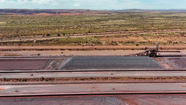 Aerial view of gray aggregate piles and industrial conveyors on red earth contrasting with the rugged landscape Rustenburg North West South Africa. Aerial view of gray aggregate piles and industrial conveyors on red earth contrasting with the rugged landscape Rustenburg North West South Africa.