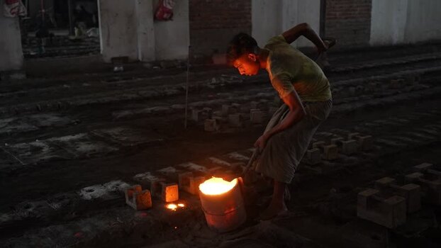 View of a worker pouring molten metal in a foundry Bangladesh.