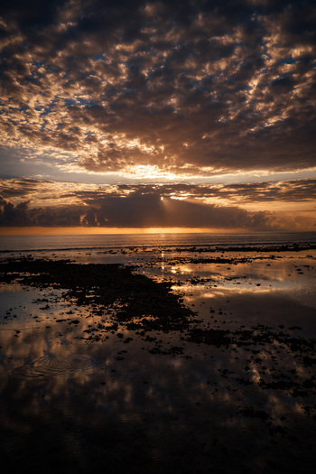 Aerial view of the sunset over the Indian Ocean with dramatic clouds reflecting in the shallow tidal pools of Mauritius Island Mauritius Moka District Mauritius. Aerial view of the sunset over the Indian Ocean with dramatic clouds reflecting in the shallow tidal pools of Mauritius Island Mauritius Moka District Mauritius.