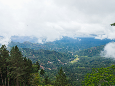 Aerial view of lush green hills and tropical vegetation under a thick layer of white clouds Gampola Central Province Sri Lanka. Aerial view of lush green hills and tropical vegetation under a thick layer of white clouds Gampola Central Province Sri Lanka.