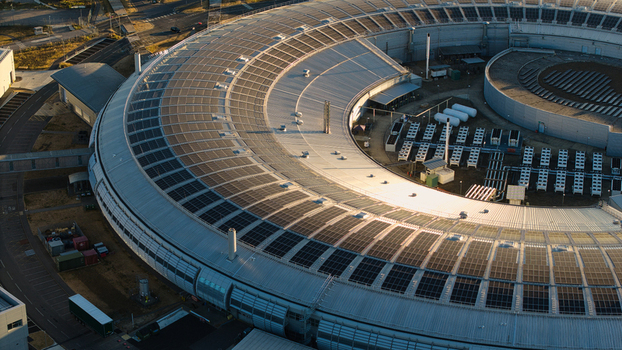 Aerial view of Diamond Light Source a circular synchrotron facility surrounded by greenery under golden hour light in Didcot United Kingdom.