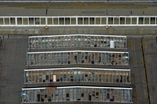 Aerial view of the weathered roof structure of an old factory with sawtooth skylights in Plock Mazowieckie Voivodeship Poland. Aerial view of the weathered roof structure of an old factory with sawtooth skylights in Plock Mazowieckie Voivodeship Poland.