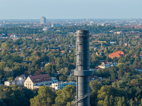 Aerial view of the Lichterfelde Combined Heat and Power Plant chimney rising above the surrounding urban landscape and greenery in Berlin Berlin Germany. Aerial view of the Lichterfelde Combined Heat and Power Plant chimney rising above the surrounding urban landscape and greenery in Berlin Berlin Germany.