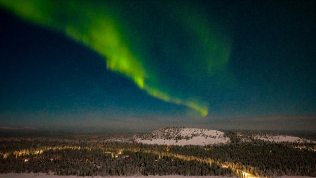 Aerial view of the vibrant green Aurora Borealis dancing over the snow covered fells and pine forests of Luosto at night in Sodankyla Lapland Finland. Aerial view of the vibrant green Aurora Borealis dancing over the snow covered fells and pine forests of Luosto at night in Sodankyla Lapland Finland.