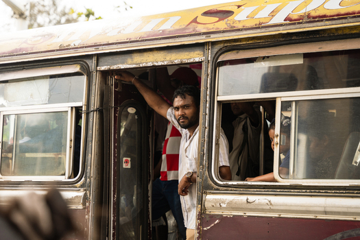 Sri Lanka 07 January 2026 View of a man looking out from a crowded yellow public bus on a street.
