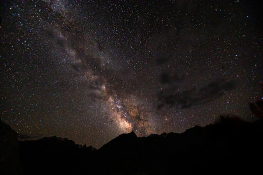 View of the Milky Way galaxy stretching across the night sky above the dark silhouettes of the Karakoram mountains near Askole Gilgit Baltistan Pakistan.