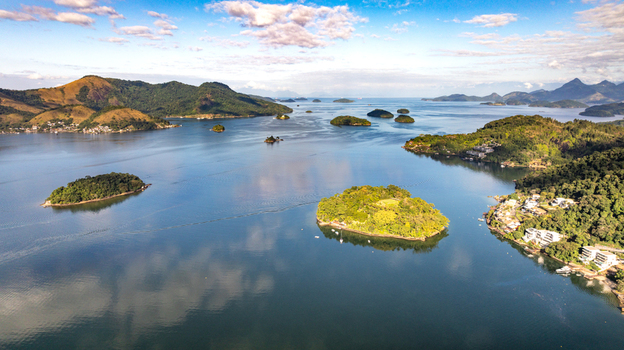 Aerial view of the lush green islands and calm blue waters of Angra dos Reis with coastal buildings nestled along the hills in Angra dos Reis Rio de Janeiro Brazil.