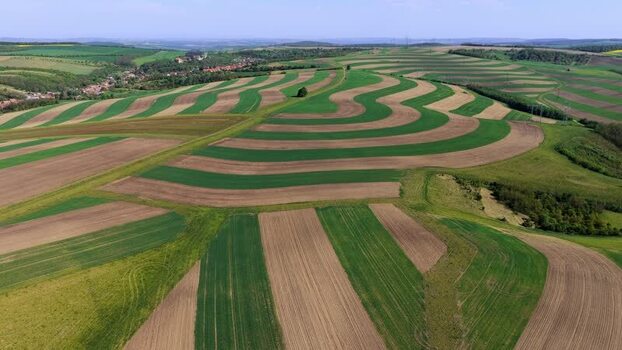 Aerial view of rolling striped agricultural fields in Brno Czechia.