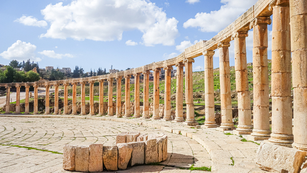 View of the ancient Roman Oval Plaza with its iconic colonnade and stone paved ground in Jerash Jerash Governorate Jordan. View of the ancient Roman Oval Plaza with its iconic colonnade and stone paved ground in Jerash Jerash Governorate Jordan.
