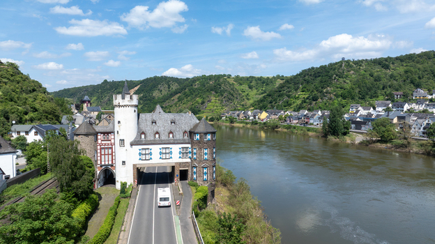 Aerial view of Schloss Leyen with the main road passing through the historic gatehouse along the Moselle river in Kobern Gondorf Rheinland Pfalz Germany. Aerial view of Schloss Leyen with the main road passing through the historic gatehouse along the Moselle river in Kobern Gondorf Rheinland Pfalz Germany.