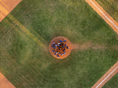 Aerial view of a baseball team gathered on the pitcher s mound in the center of a green field in Santo Domingo Distrito Nacional Dominican Republic.