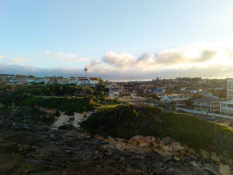 Aerial view of residential houses on the cliffside overlooking the rocky shoreline at sunset in Dee Why New South Wales Australia. Aerial view of residential houses on the cliffside overlooking the rocky shoreline at sunset in Dee Why New South Wales Australia.