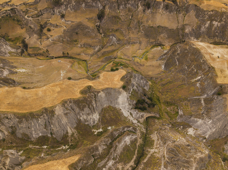 Aerial view of Toachi River Canyon featuring rugged rocky cliffs winding river and golden agricultural fields in the arid landscape of Zumbahua Cotopaxi Ecuador. Aerial view of Toachi River Canyon featuring rugged rocky cliffs winding river and golden agricultural fields in the arid landscape of Zumbahua Cotopaxi Ecuador.
