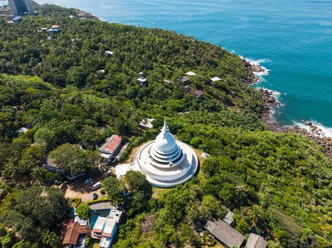 Aerial view of the Japanese Peace Pagoda Rumassala surrounded by lush tropical forest and the turquoise ocean in Unawatuna Southern Province Sri Lanka. Aerial view of the Japanese Peace Pagoda Rumassala surrounded by lush tropical forest and the turquoise ocean in Unawatuna Southern Province Sri Lanka.