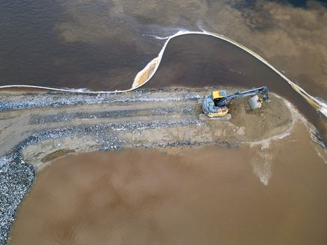 Oulu Finland 18 September 2026 Aerial view of an excavator working on a construction site at the waterfront with a silt curtain visible in the murky water. Oulu Finland 18 September 2026 Aerial view of an excavator working on a construction site at the waterfront with a silt curtain visible in the murky water.