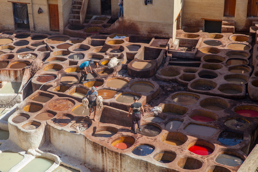 View of workers processing leather in the colorful dye vats of the historic tannery in Fez Morocco.